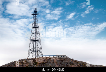 Big communication radio tower above blue cloudy sky Stock Photo