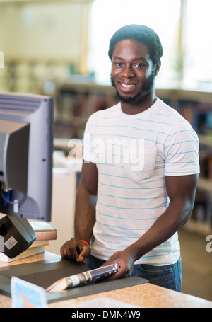 Librarian Scanning Books At Counter In Library Stock Photo