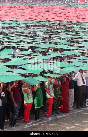 Dhaka, Bangladesh. 16th Dec, 2013. Members of Bangladesh Army, Defense officials and schoolchildren form the world's largest human national flag to mark the country's Victory Day in Dhaka on December 16, 2013. A total of 27,117 volunteers, mostly students, used coloured tiles to form the flag at Dhaka's National Parade Ground. Bangladesh won independence from Pakistan after a bitter nine-month war in 1971 led by the country's founder Sheikh Mujibur Rahman, and this is celebrated every year on December 16. Credit:  Monirul Alam/ZUMAPRESS.com/Alamy Live News Stock Photo