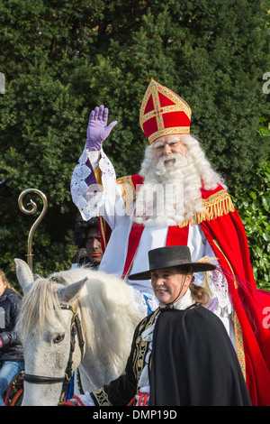 Netherlands, Kortenhoef, Saint Nicholas eve. Saint on white horse or roan and Black Petes make a tour through the village Stock Photo
