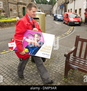 Dunblane postman John Elliot with a commemerative Andy Murray stamp at newly painted gold post box following Murray's win at Stock Photo