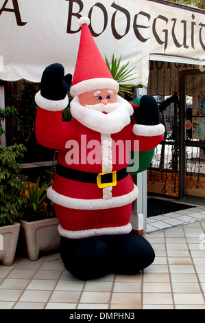 Inflatable Father Christmas in shopping street, Caleta de Fuste, Fuerteventura, Canary Islands. Stock Photo