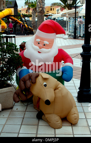 Inflatable Father Christmas in shopping street, Caleta de Fuste, Fuerteventura, Canary Islands. Stock Photo