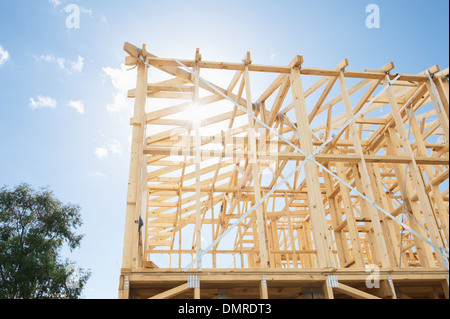 New residential construction home framing against a blue sky. Stock Photo