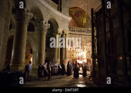 Orthodox Christian priests performing a night liturgy around the Aedicule inside the Church of the Holy Sepulchre. Stock Photo