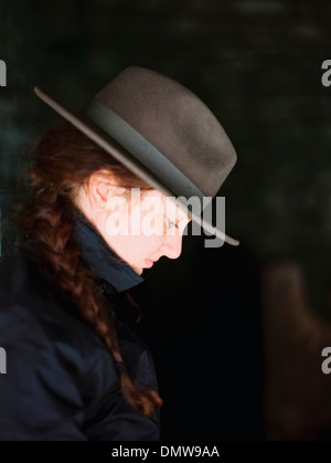 Profile of a woman wearing a felt hat with a brim. Stock Photo