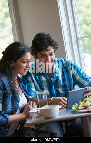 A couple seated looking at a digital tablet. Stock Photo