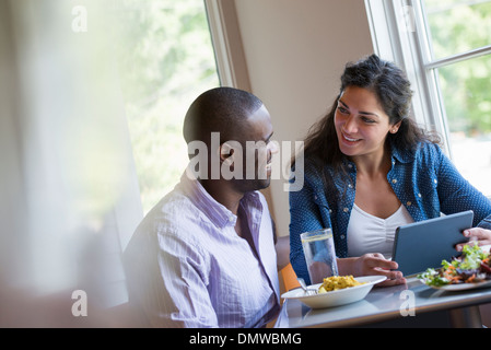 A couple seated looking at a digital tablet. Stock Photo