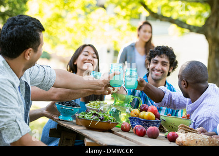 A group of people holding glasses and making a toast by clicking glasses. Stock Photo