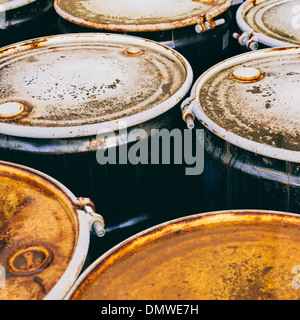 A group of rusted corroded barrels of chemical or petroleum products. Stock Photo