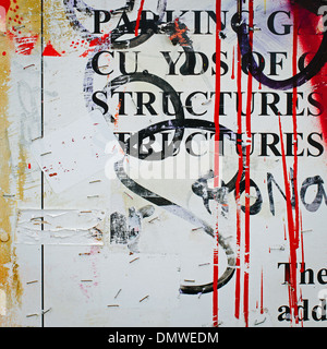 A graffiti covered wall in a city. Streaks of paint drips and printed messages covered with spraypaint tags. Stock Photo
