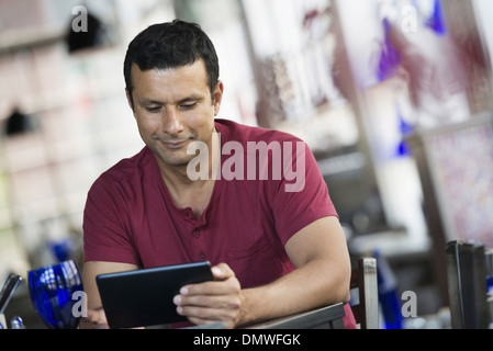 A cafe interior. A man sitting using a digital tablet. Stock Photo
