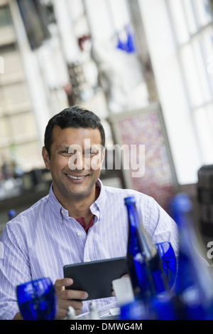 A cafe interior. A man sitting using a digital tablet. Stock Photo