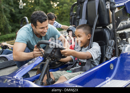 Boys and men go-karting on a track. Stock Photo