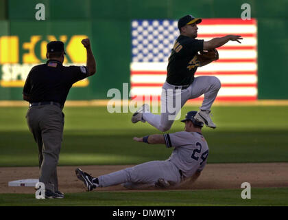 Oct 13, 2001; Oakland, CA, USA;Oakland A's second baseman Frank Menechino throws to first after getting New York Yankee, Tino Martinez, out to complete a double play in the second inning hits into a fielders choice in the fourth inning during play at Network Associates Colosium in Oakland, Calif. at the American League Division Series on Saturday, October, 13, 2001.  Jermaine Dye w Stock Photo