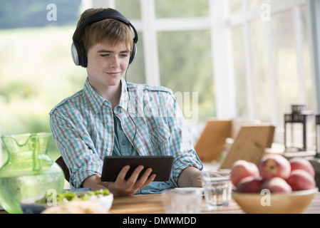 A young boy listening to music and using a digital tablet. Stock Photo