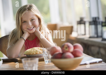 A young girl looking at a pastry pie smiling. Stock Photo