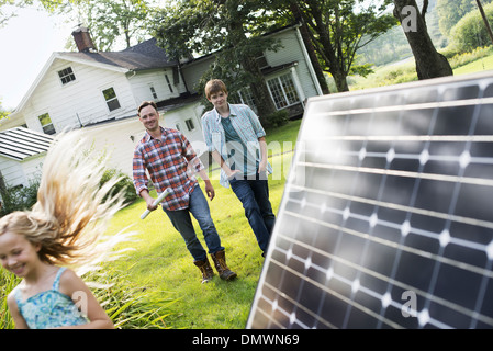 Two people walking towards a farmhouse garden. Stock Photo