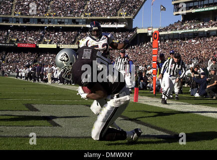 Dec 22, 2002; Oakland, CA, USA; Oakland Raiders' Charlie Garner, #25, catches a touchdown as Denver Broncos' Ian Gold, #52, watches the play in the 2nd quarter of their game on Sunday, December 22, 2002 at Network Associates Coliseum in Oakland, Calif. Stock Photo