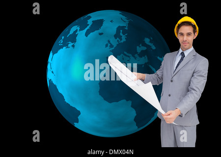 Composite image of serious architect with hard hat holding plans Stock Photo