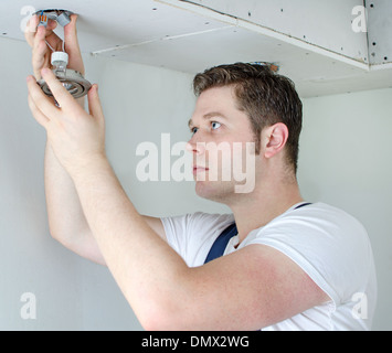 Certified electrician installing socket for light bulb Stock Photo