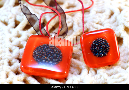 origina red glass handmade ring and amulet on knitted background Stock Photo