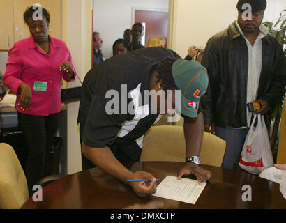 Feb 01, 2006; Boca Raton, FL, USA; Atlantic High School senior, Orlando Franklin, center, signs scholarship papers to the University of Miami while his mother, Sylvia Allen, back left, and father, Kelvin Jones, back right, watch on February 1, 2006.  Mandatory Credit: Photo by Chris Matula/Palm Beach Post /ZUMA Press. (©) Copyright 2006 by Palm Beach Post Stock Photo