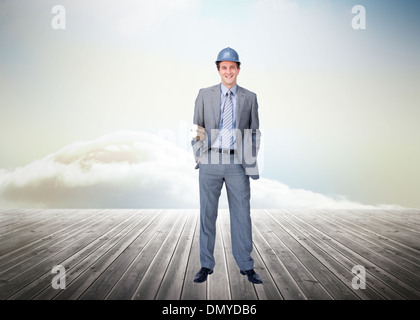 Composite image of smiling attractive architect on phone holding plans Stock Photo