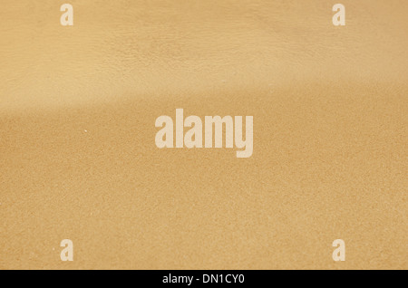 Blue Sandy beach background. Detailed sand texture and water . Top view Stock Photo