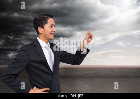 Composite image of smiling asian businessman pointing Stock Photo