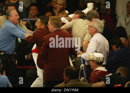 Apr 08, 2006; Las Vegas, NV, USA; FLOYD MAYWEATHER JR. vs ZAB JUDAH IBF Welterweight Fight. When JUDAH Punched MAYWEATHER below the belt  ROGER MAYWEATHER (white & red jogging suit)trainer & Uncle jumped into the ring & went after ZAB JUDHA (R) red & black trunks. Nevada athletic Chief Inspector TONY LATO background Blue shirt & inspectors in burgandy jackets along with the Metro p Stock Photo