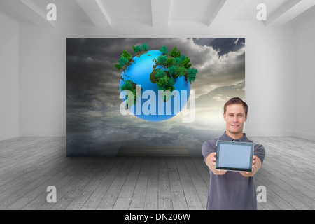 Composite image of young man showing screen of his tablet computer Stock Photo