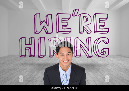 Smiling businessman standing in front of were hiring graphic Stock Photo