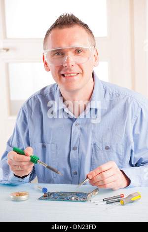 Man using soldering tool for the computer parts. Stock Photo