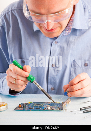 Man using soldering tool for the computer parts. Stock Photo