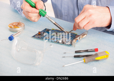 Man using soldering tool for the computer parts. Stock Photo