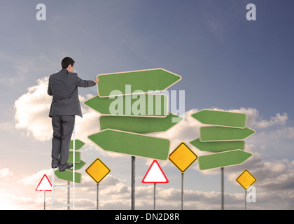 Composite image of businessman standing on ladder Stock Photo