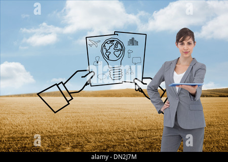 Composite image of attractive businesswoman holding tablet pc Stock Photo