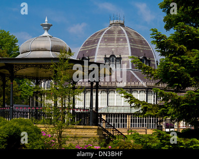 Pavilion Gardens in Buxton Derbyshire Peak District England UK with the dome of the Octagon visible behind the bandstand Stock Photo