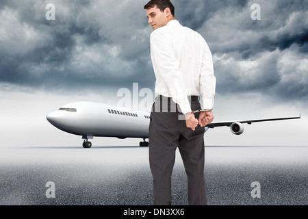 Composite image of businessman wearing handcuffs Stock Photo