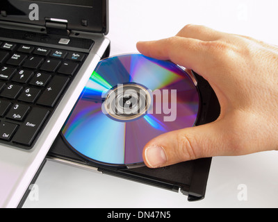 Inserting a CD into a CD rom drive on a laptop computer Stock Photo - Alamy