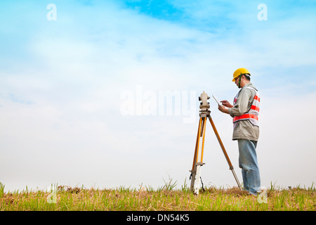 Surveyor engineer making measure on the field with tablet pc Stock Photo