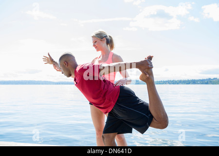 Caucasian man practicing yoga with teacher Stock Photo