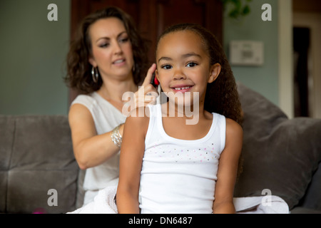 Mother fixing daughter's hair Stock Photo