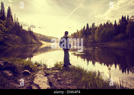 Caucasian man fishing at lakeside Stock Photo