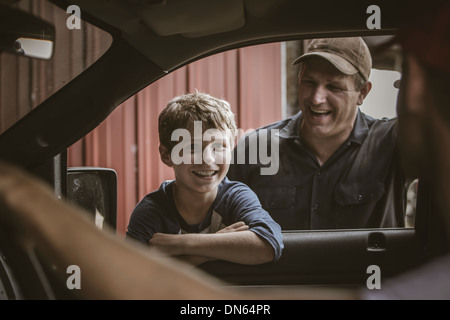 Caucasian father and son talking in car window Stock Photo