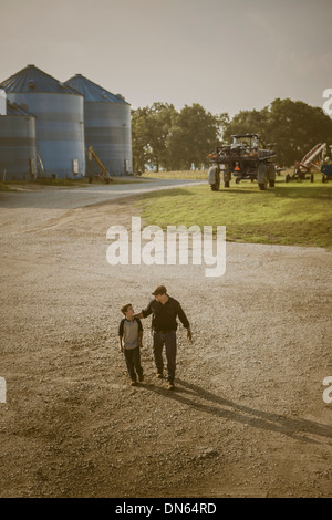 Caucasian father and son walking on farm Stock Photo