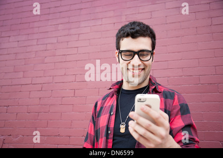 Hispanic man using cell phone outdoors Stock Photo