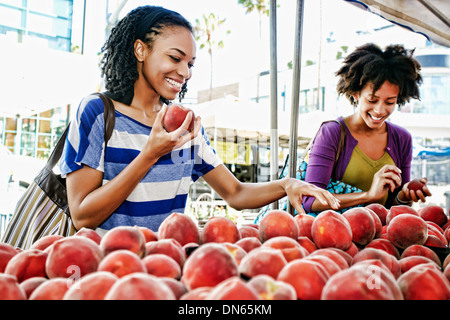 Women shopping together at fruit stand Stock Photo