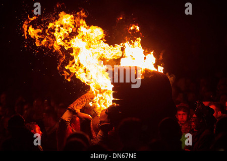 Participants run with a burning tar barrel through the streets of Ottery St Mary, Devon. Stock Photo